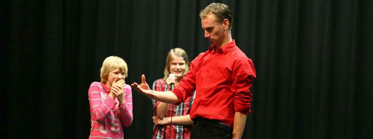 Acteurs van The Big Mo brengen samen met leerlingen improvisatietheater tot leven op schoolpodium.