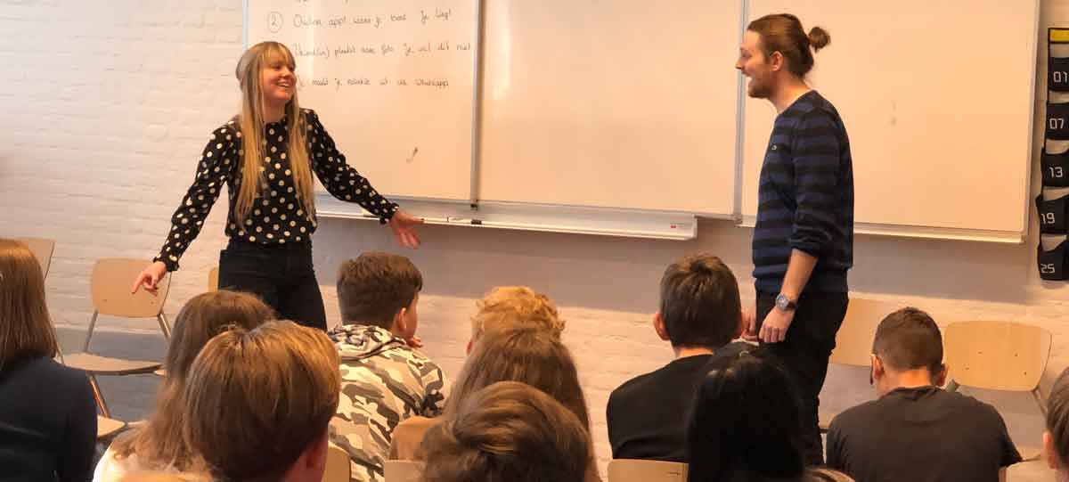 Twee acteurs van The Big Mo spelen een interactieve schoolvoorstelling in een klaslokaal.