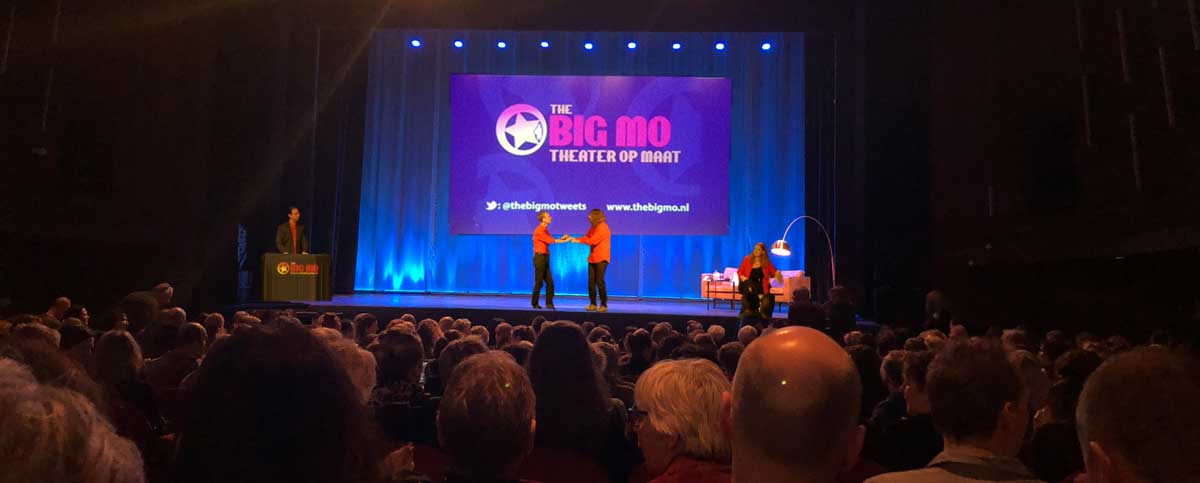 Volle zaal met ouders die kijken naar de interactieve voorstelling tijdens de ouderavond in het schooltheater